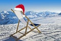 Santa hat on a deckchair on the side of a ski slope, snowy mountain Royalty Free Stock Photo