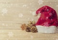 Santa hat and golden pine cones glittered christmas and gift box decoration on wood table background. copy space