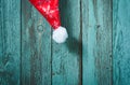 Santa hat hanging on turquoise wooden background Royalty Free Stock Photo