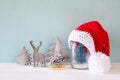 santa hat on mason jar with christmas tree.