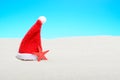 Santa hat next to a starfish on a sunny beach