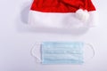 Santa hat with a protective mask on a white background, top view. christmas coronavirus concept Royalty Free Stock Photo