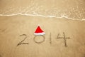 2014 with santa hat on sea beach sand Royalty Free Stock Photo