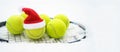 Santa hat on tennis ball, set of tennis balls on racket on white snow winter background. Merry Christmas and New year concept with Royalty Free Stock Photo