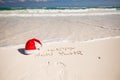 Santa Hat on white sandy beach and Happy New Year Royalty Free Stock Photo