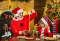 Santa helper. Cute little child boy and daddy make gingerbread cookies, near Christmas tree. Merry Christmas and Happy