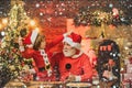 Santa helper. Kid grandson and grandfather in Santa Hat Writing Wish List - unfocused lights background. Child write Royalty Free Stock Photo