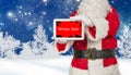 Santa holds tablet with winter sale advertising on wintery background Royalty Free Stock Photo