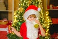 Santa in home. Santa Claus eating cookies and drinking milk on Christmas Eve. Kid Santa Claus enjoying in served Royalty Free Stock Photo