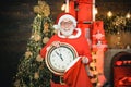 Santa make funny face and holding clock showing five minutes to midnight. Happy Christmas Santa. Its almost twelve clock Royalty Free Stock Photo