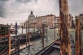 Santa Maria della Salute, Grand Canal view with gondolas around a wooden pier in a rainy autumn day, Venice, Italy