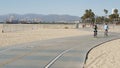 SANTA MONICA, LOS ANGELES CA USA - 28 OCT 2019: California summertime beach aesthetic, people walking and ride cycles on bicycle