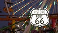 SANTA MONICA, LOS ANGELES, USA - 28 OCT 2019: Iconic road sign glowing, historic route 66. Famous california symbol, pier of