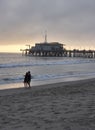 Santa Monica pier in the evening, a couple standing at the beach, the last rays of sunshine Royalty Free Stock Photo