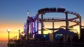 SILHOUETTE: People gather on pier to watch the sunset and ride the rollercoaster
