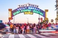 people have fun entering the pier to the amusement area pacific park on the pier of Santa Monica by night