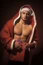Santa with muscular body in red coat.