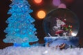 Santa near a beautiful, colourful, New Year`s fir-tree, sits in a glass sphere and prepares gifts for children for new year