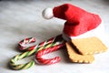 Santa red hat, three lollipops and two shortbread. Christmas and new year sweets Royalty Free Stock Photo