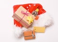 Santa red hat white background top view. Santa hat with christmas gift box. Keep family traditions. Christmas presents
