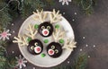 Santa reindeers made of cookies, chocolate, marshmallows and coconut flakes on plate on brown background. Christmas Royalty Free Stock Photo