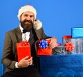 Santa in retro suit presents blue and red gifts. Royalty Free Stock Photo