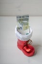 A Santa`s boot with a banknote as a Christmas present