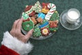 Santa's Hand Taking Homemade Decorated Cutout Christmas Cookies