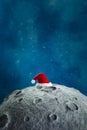 Santa\'s hat on the moon against the background of the night starry sky