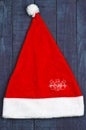 Santa's red cap on blue wooden background. Snowman. Royalty Free Stock Photo