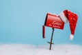 Santa`s red mailbox with snow isolated on bright blue background. Letters to Santa with Xmas wishes Royalty Free Stock Photo