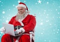 Santa sitting on chair and using laptop Royalty Free Stock Photo