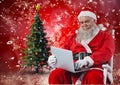 Santa sitting on chair and using laptop Royalty Free Stock Photo