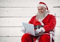 Santa sitting on chair and using laptop Royalty Free Stock Photo