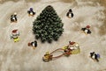 Santa in sleigh with reindeer run around green Christmas tree and many penguins and snow man