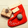 Santa stocking with christmas gift box. Keep family traditions. Christmas decorative sock light background top view