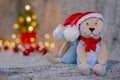 Santa teddy bear doll wearing santa hat with bokeh light background of Christmas tree Royalty Free Stock Photo