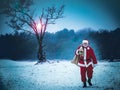 SantaClaus with a bag of gifts walking on snow-covered field. Wi Royalty Free Stock Photo