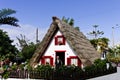 Santana, Madeira, Portugal: an old man in the garden of a traditional white house of Santana with a thatched roof