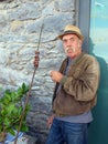 An old Portuguese man with mustache enjoying traditional grilled beef on bay laurel skewers