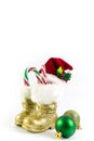 Santas golden boots and red hat with Christmas balls Royalty Free Stock Photo