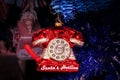 Santas Hotline red retro telephone ornament hanging on blue Christmas tree - Closeup and glittery on dark blurred background- Room Royalty Free Stock Photo