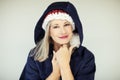 Santas little helper. Beautiful happy senior woman with a santa claus hat, and winter jacket