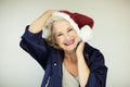 Santas little helper. Beautiful happy senior woman with a santa claus hat, and winter jacket Royalty Free Stock Photo