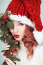 Santas little helper. Beautiful happy young woman with a santa claus hat