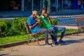 SANTIAGO, CHILE - SEPTEMBER 13, 2018: Unidentified people sitting in a public wooden chair relaxing at Yungay park