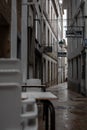 Stacked Plastic Chairs in the Rain in Old Rustic Spanish Street of Santiago de Compostela Royalty Free Stock Photo