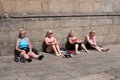 Santiago de Compostela, Spain; july 7, 2019: Group of mature women tourists resting on paving stone with burnt skin. Sun damage Royalty Free Stock Photo