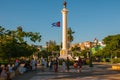 SANTIAGO DE CUBA, CUBA: Column of Liberty on Plaza de Marte square. Cuba flag develops on the background of the sky