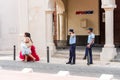 SANTO DOMINGO, DOMINICAN REPUBLIC - AUGUST 8, 2017: Two women in beautiful dresses and policemen in a city street. Copy space for